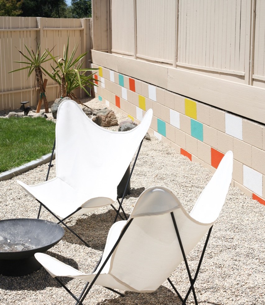mid century yard landscape exterior painted mosaic cinderblock cinder block brick retaining wall butterfly chairs firepit colorful backyard