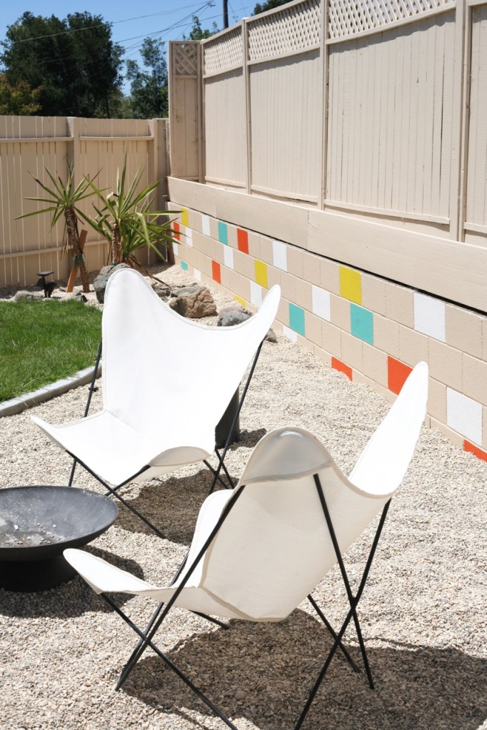 mid century yard landscape exterior painted mosaic cinderblock cinder block brick retaining wall butterfly chairs firepit colorful backyard