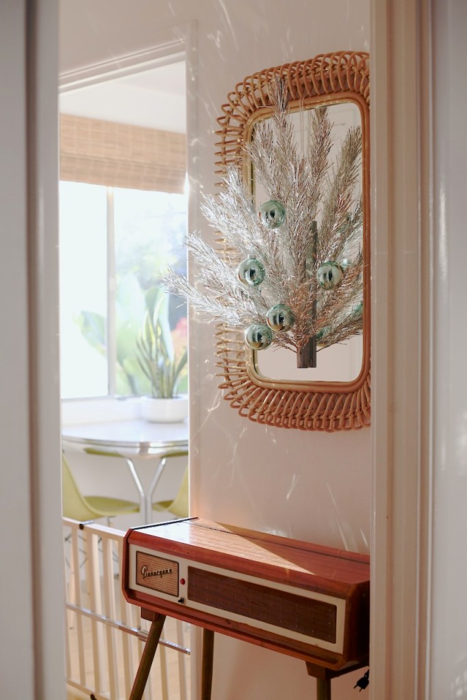 small hanging aluminum christmas on wall with vintage glass ornaments