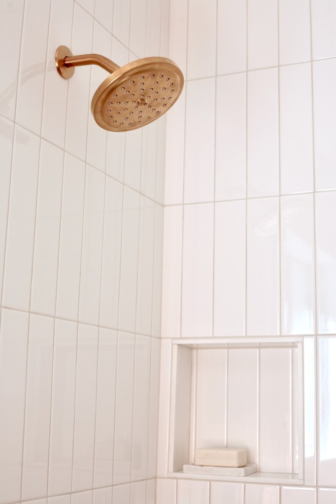 Moen Align brushed gold shower trim head modern mid century bathroom Laticrete Light Pewter grout shower light gray neutral subway white tile shower niche