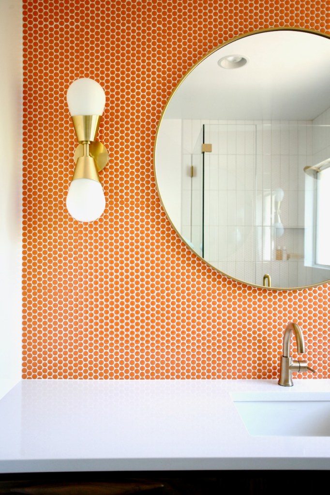 Orange penny tile Festival Turmeric retro mid century bathroom Delta Trinsic faucet Mitzi Cora sconce silestone white storm